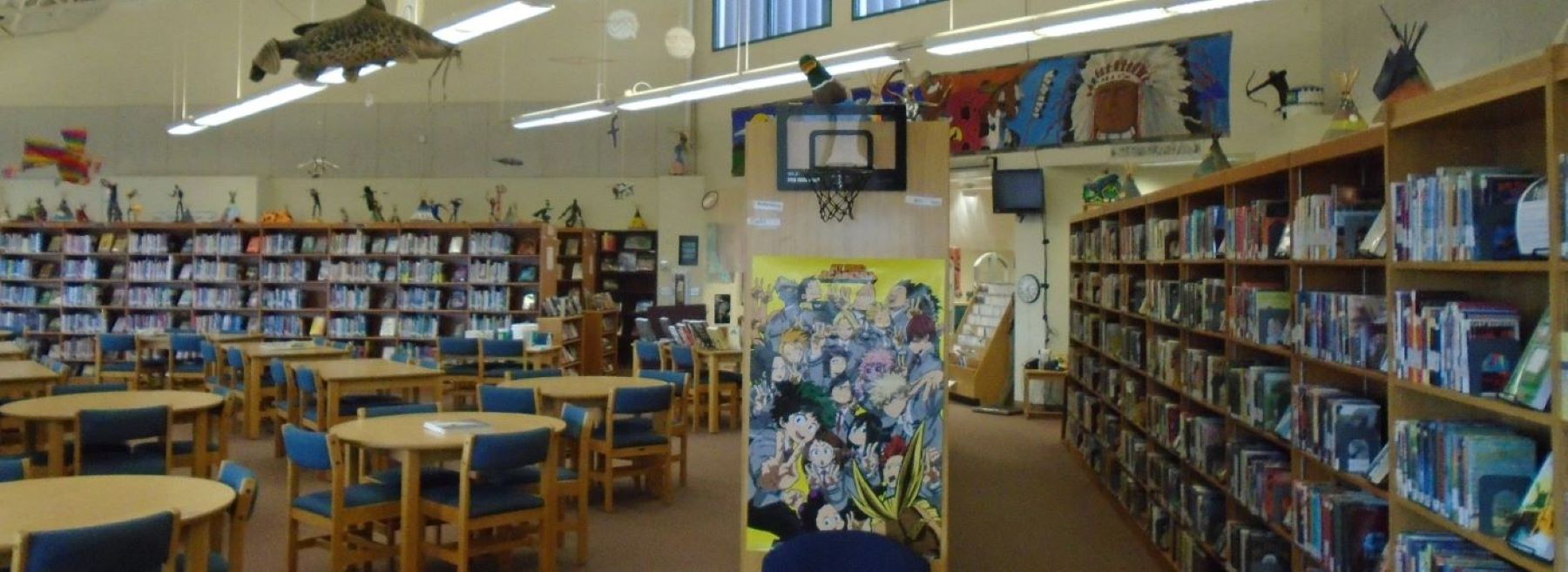 A spacious library filled with numerous bookshelves and tables for reading and studying.